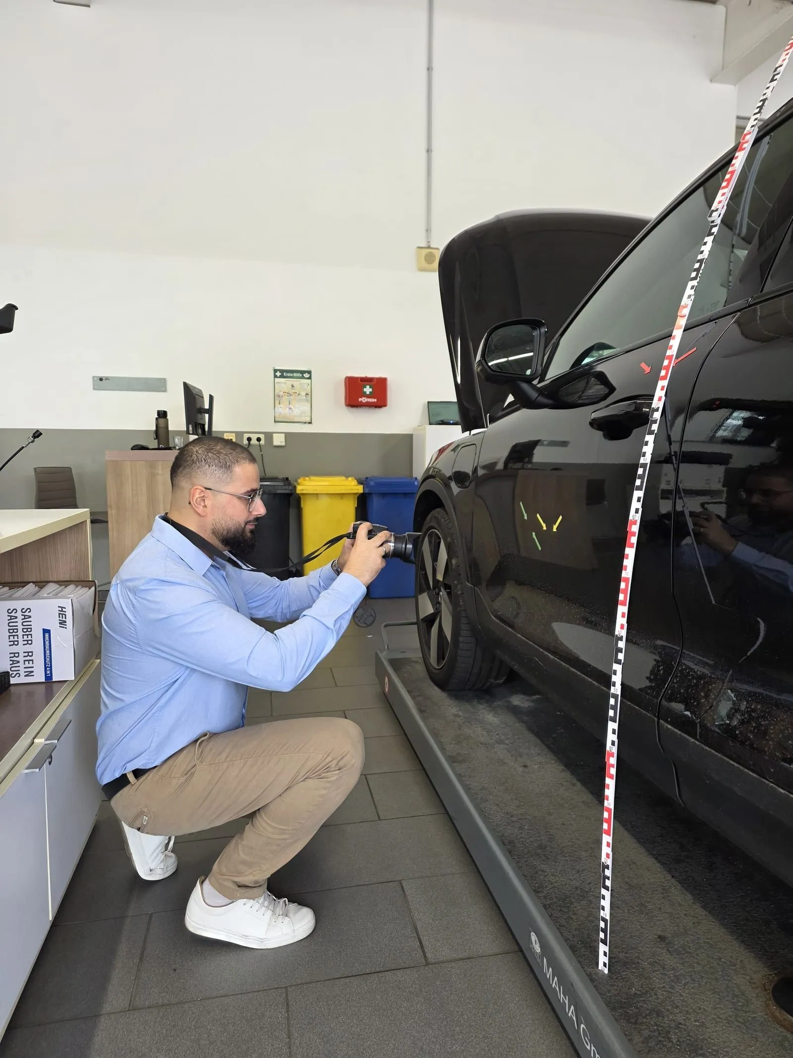 Aufnahme eines Streifschadens an der Fahrzeugseite mit Kamera und Messlatte.
